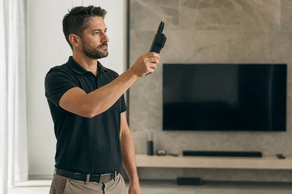 Tecnico con rilevatore RF durante un controllo in ambiente domestico moderno
